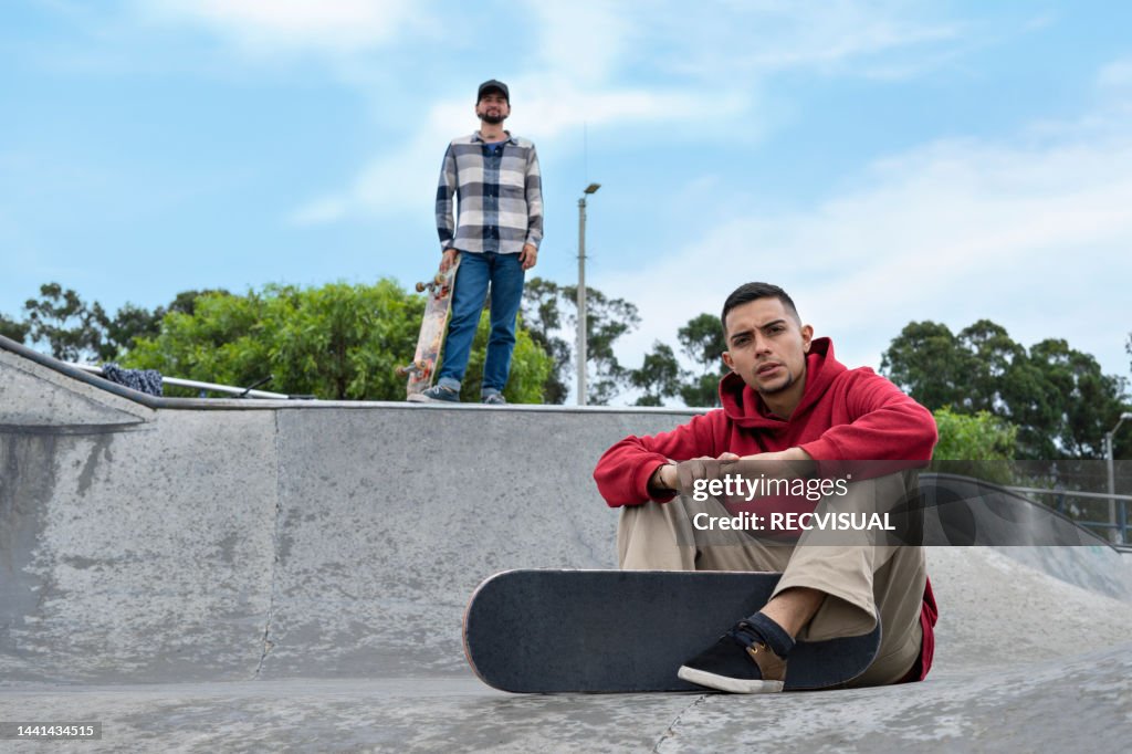 Porträt eines jungen lächelnden Skateboarders in einem Skatepark.