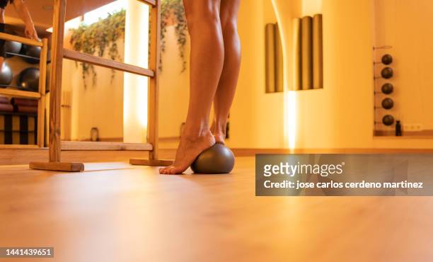 close-up of bare feet stepping on a small ball, ballet teacher training - womans bare feet fotografías e imágenes de stock