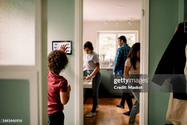 boy using digital tablet while family in kitchen at home - copilot ストックフォトと画像