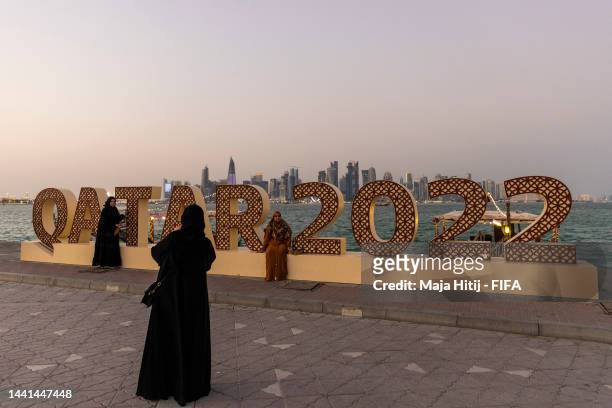Members of the public pose for a pictures next to a Qatar 2022 logo at Doha Corniche ahead of the FIFA World Cup Qatar 2022 on November 14, 2022 in...