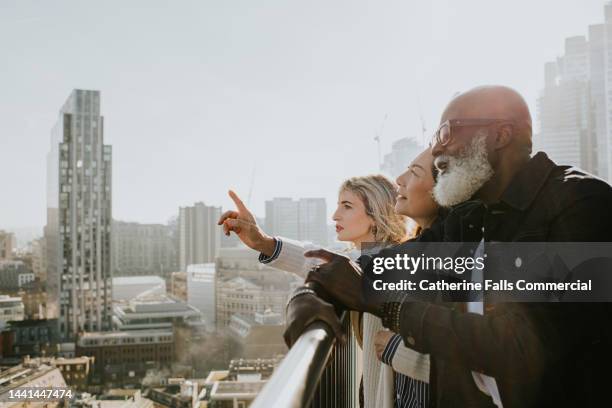 a group of people enjoy a sunny cityscape view - city scape stock pictures, royalty-free photos & images