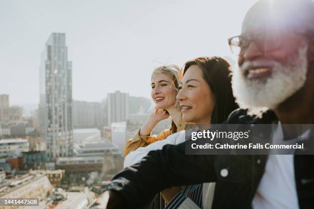 a group of people enjoy a sunny cityscape view - looking at view stock pictures, royalty-free photos & images