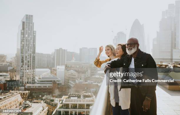 a group of people enjoy a sunny cityscape view - city break friends stock pictures, royalty-free photos & images