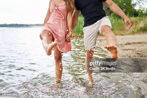 young couple splashes water with their feet - leipzig saxony stockfoto's en -beelden