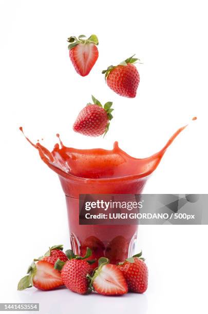 strawberries falling into a glass of juice,italy - blended drink ストックフォトと画像