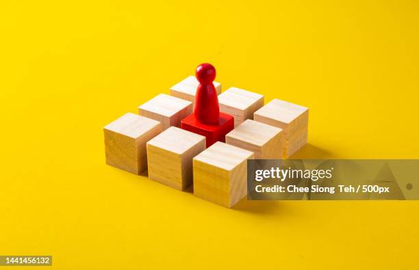 red wooden block standing out from the group wooden blocks on yellow background,malaysia - philosophy stock pictures, royalty-free photos & images