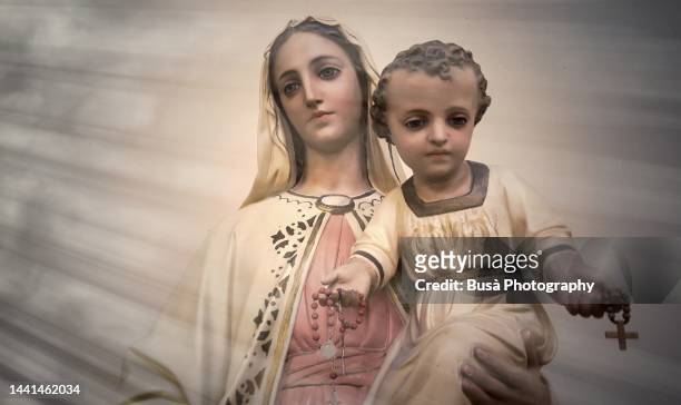 statue of virgin mary carrying baby jesus - purity foto e immagini stock