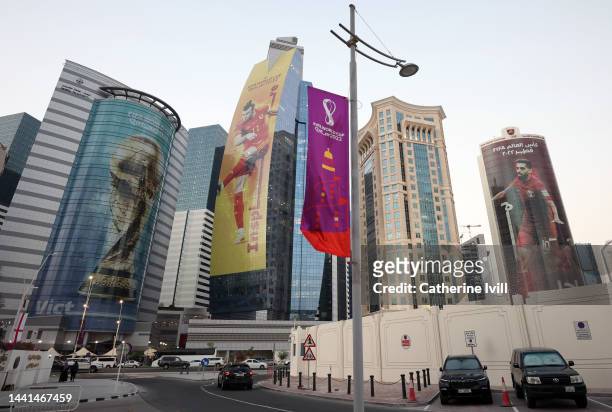 Images of Gareth Bale of Wales, Hassan Al-Haydos of Qatar and the FIFA World Cup trophy are seen on sky scrapers in the West Bay area ahead of the...