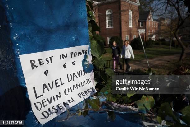Students walk past a sign memorializing three University of Virginia football players killed during an overnight shooting at the university on...