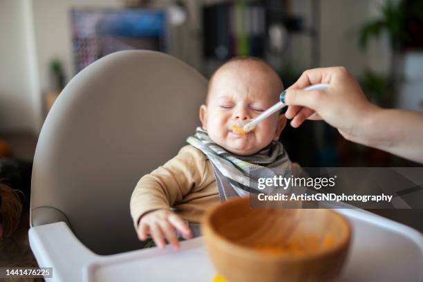 baby isst püree und mag es nicht. - unangenehmer geschmack stock-fotos und bilder