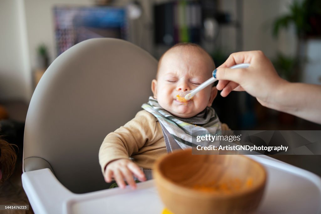Baby eating puree and not liking it.