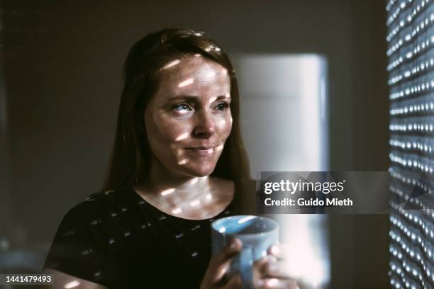 woman holding a fresh cup of coffee in her hand in the morning. - coffee cup light stock pictures, royalty-free photos & images