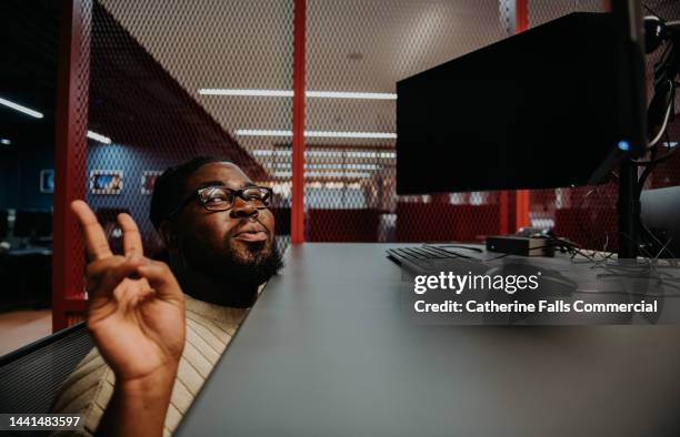 comical image of a young employee messing around with a adjustable standing desk - showing off fotografías e imágenes de stock