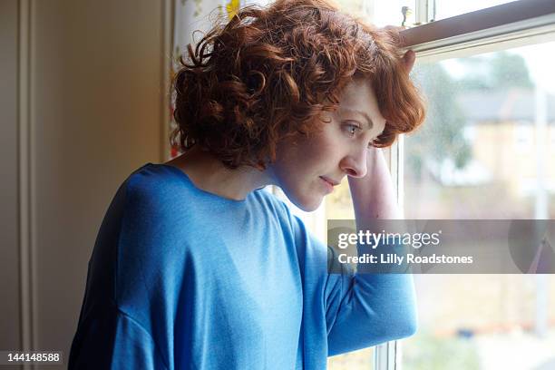 girl looking out of window - anxiety stock pictures, royalty-free photos & images