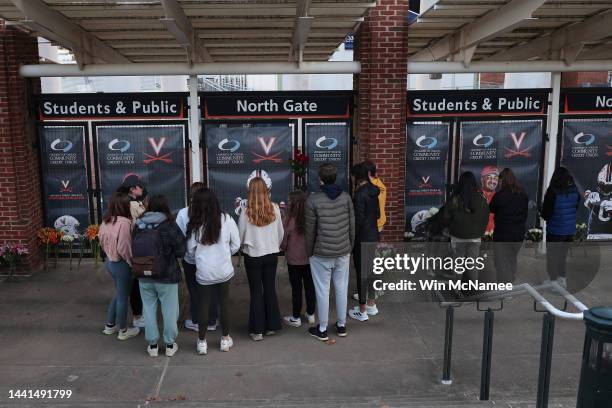 University of Virginia students gather to place flowers at a makeshift memorial outside of Scott Stadium for three University of Virginia football...