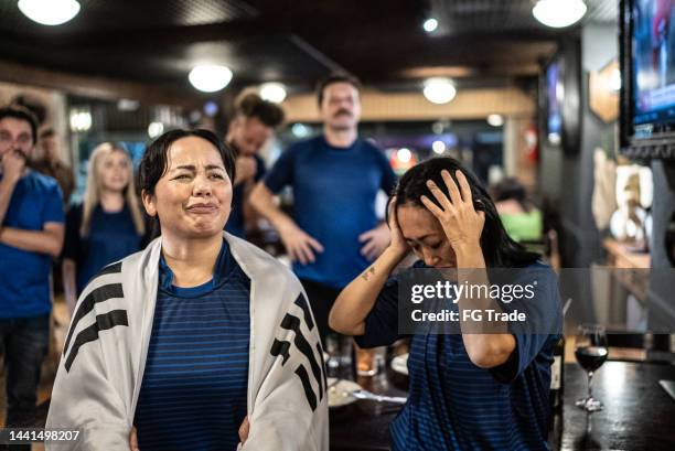 group of friends disappointed while rooting for their team at bar - cross channel stock pictures, royalty-free photos & images