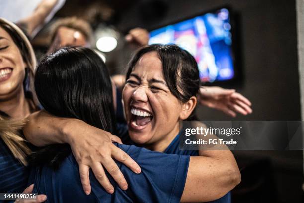 friends rooting for their team and celebrating at bar - fans embracing stock pictures, royalty-free photos & images