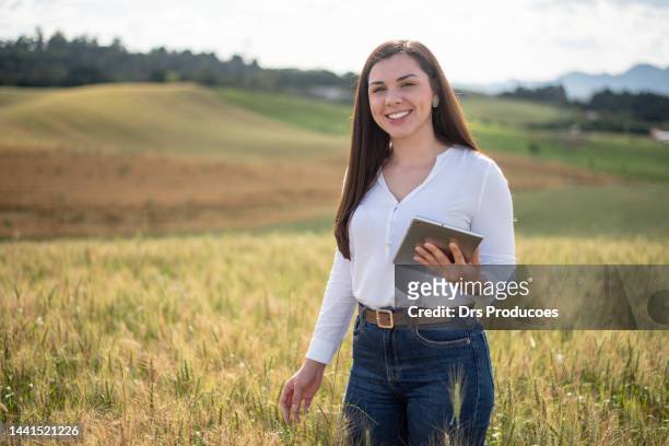 portrait of female agronomy looking at wheat field - young agronomist stock pictures, royalty-free photos & images