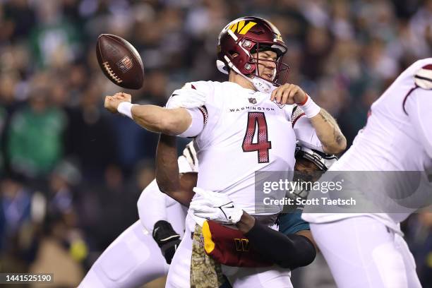 Taylor Heinicke of the Washington Commanders fumbles the ball against Josh Sweat of the Philadelphia Eagles during the first quarter in the game at...