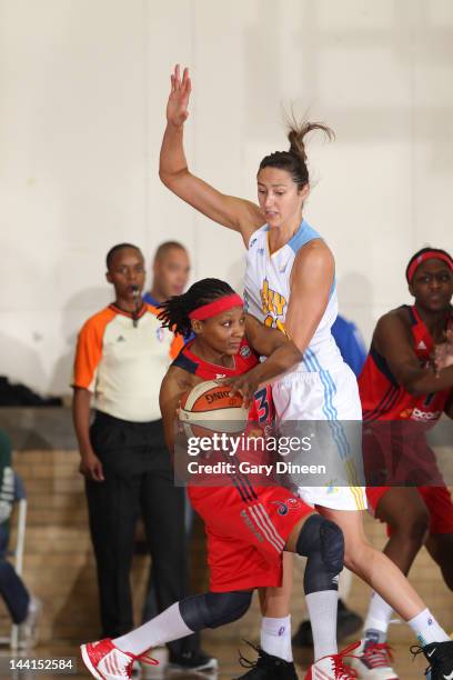 Dominique Canty of the Washington Mystics looks to pass while defended by Ruth Riley of the Chicago Sky on May 10, 2012 at New Trier High School in...