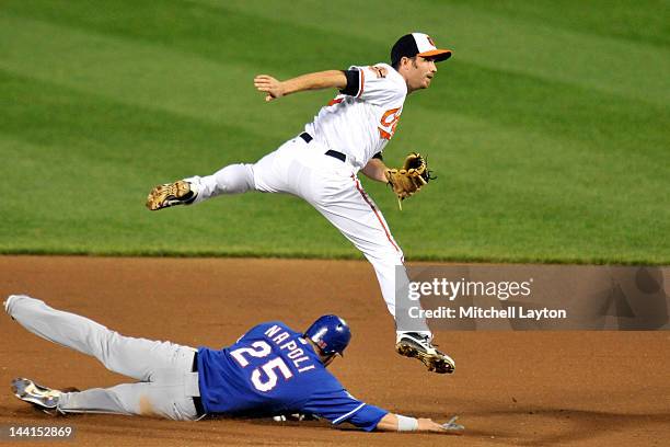 Hardy of the Baltimore Orioles forces out Mike Napoli of the Texas Rangers as he slides into second base during the seventh inning of a baseball game...