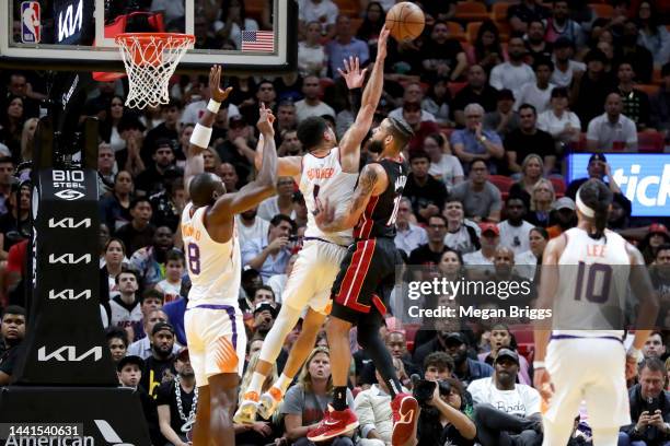 Devin Booker of the Phoenix Suns blocks a shot by Caleb Martin of the Miami Heat during the fourth quarter at FTX Arena on November 14, 2022 in...