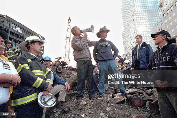 President George W. Bush speaks to rescue workers, firefighters and police officers from the rubble of Ground Zero September 14, 2001 in New York...