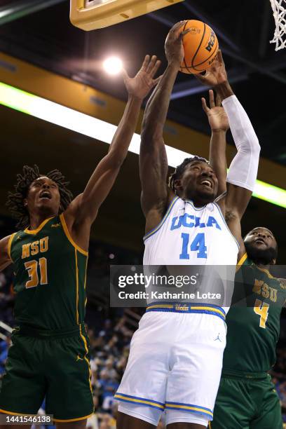 Kenneth Nwuba of the UCLA Bruins grabs a rebound away from Cahiem Brown and Joe Bryant Jr. #4 of the Norfolk State Spartans during the first half of...