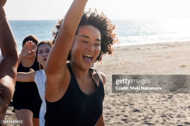 the women high-five and rejoice with each other. - beach volleyball friends stock pictures, royalty-free photos & images