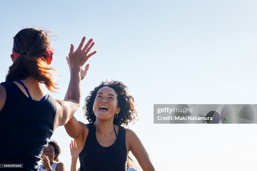 The women high-five and rejoice with each other.