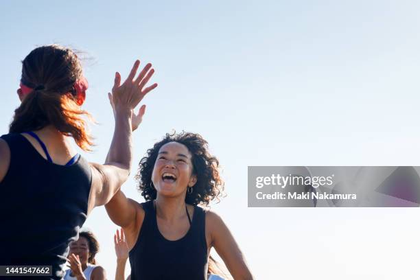 the women high-five and rejoice with each other. - deporte de equipo fotografías e imágenes de stock