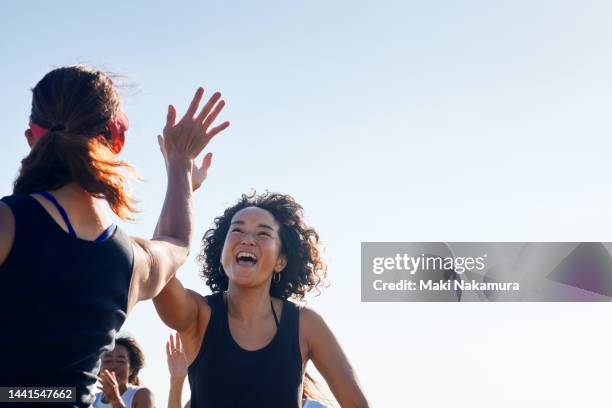 the women high-five and rejoice with each other. - esperanza fotografías e imágenes de stock