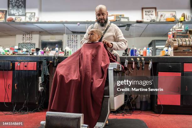 black customers receive a haircut from barbers at a black owned barbershop - barber shop 3 stock pictures, royalty-free photos & images