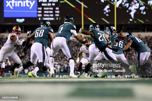 Jalen Hurts of the Philadelphia Eagles attempts to hand the ball off to Miles Sanders against the Washington Commanders during the fourth quarter in...