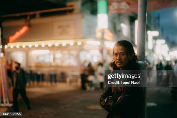 man looking at camera in tokyo night market - ameya yokocho fotografías e imágenes de stock