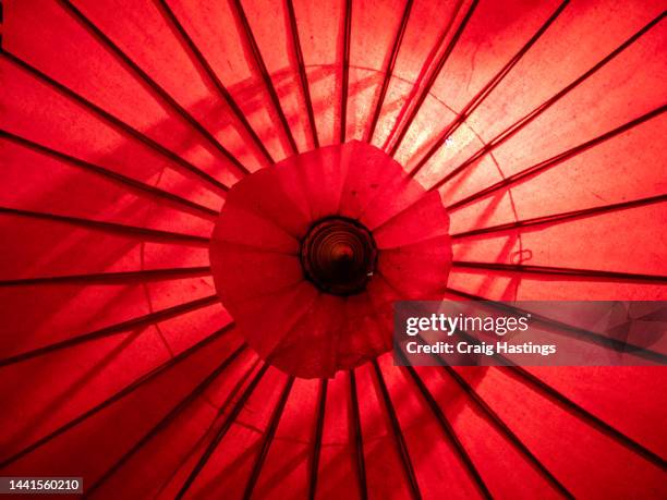 full frame wide view of the top side of red, waxed paper umbrella typical of asian culture found in japan, china, vietnam and thailand - myanmar culture stockfoto's en -beelden