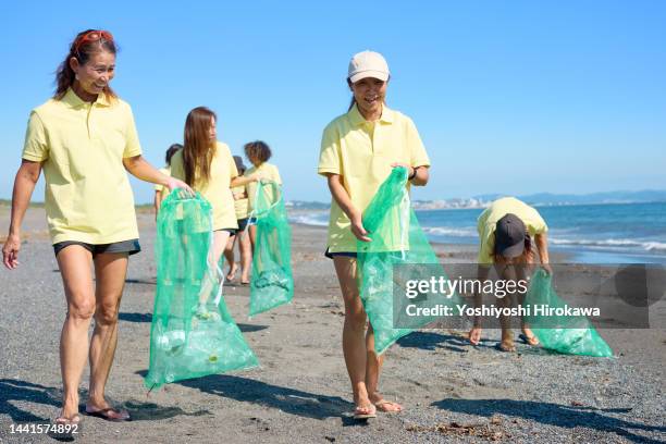 senior women cleaning up beach - 茅ヶ崎市 fotografías e imágenes de stock