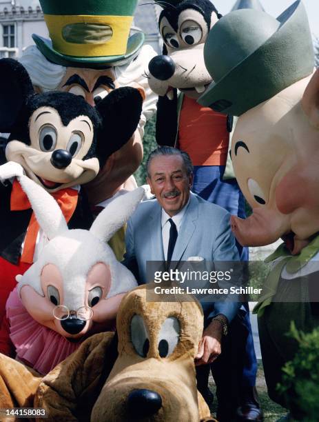 American animator and film director Walt Disney poses with actors costumed as some of his company's famous creations, Anaheim, California, November...