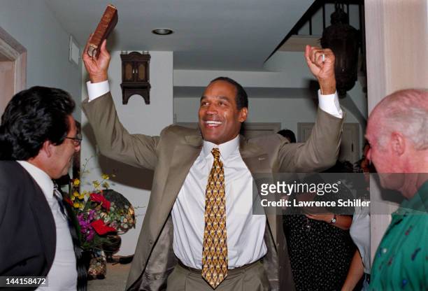 At his home after leaving the courtroom, American former professional football player and actor O.J. Simpson celebrates his acquittal on double...