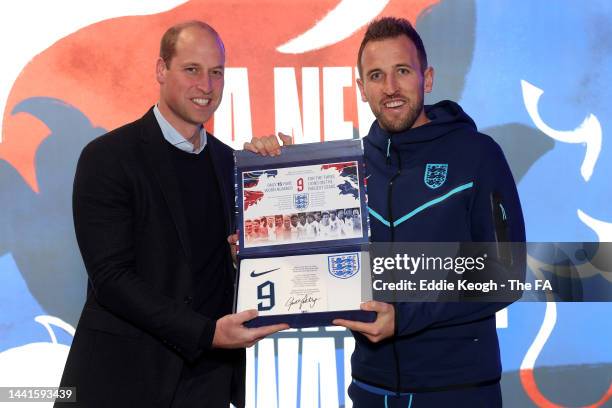 Prince William, Prince of Wales presents an England shirt to Harry Kane of England at St George's Park on November 14, 2022 in Burton upon Trent,...