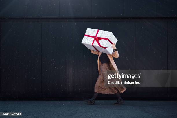 eine anonyme frau bedeckt gesicht mit einem großen weihnachtsgeschenk - groß stock-fotos und bilder