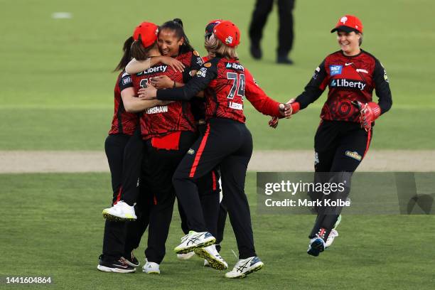 Erica Kershaw and Shabnim Ismail of the Renegades celebrate with their team after combining for the wicket of Phoebe Litchfield of the Thunder during...