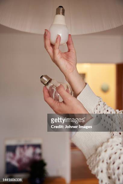 woman's hands changing light bulb - energy efficient lightbulb bildbanksfoton och bilder