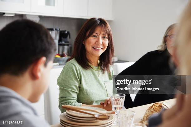 family sitting at table before meal - house warming stock pictures, royalty-free photos & images