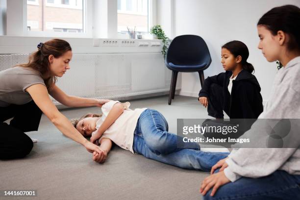 teacher giving first aid training - recovery position stock pictures, royalty-free photos & images
