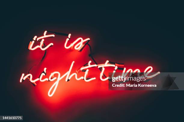 red neon light sign with a title: it is nighttime. - alphabet neon stock pictures, royalty-free photos & images