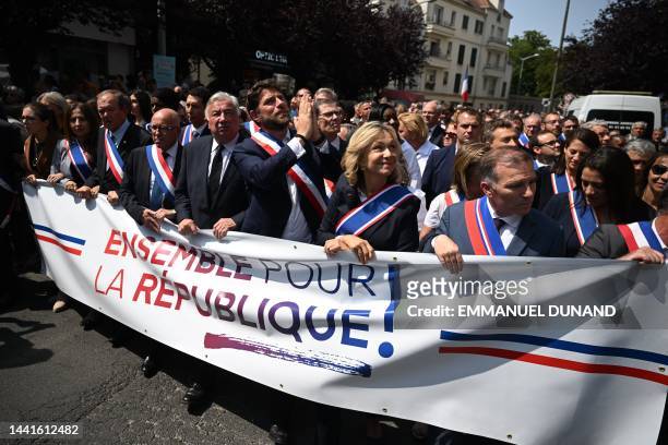 The Mayor of L'Hay-les-Roses Vincent Jeanbrun gestures next to a banner reading "together for the republic" held by to President of French ruling...