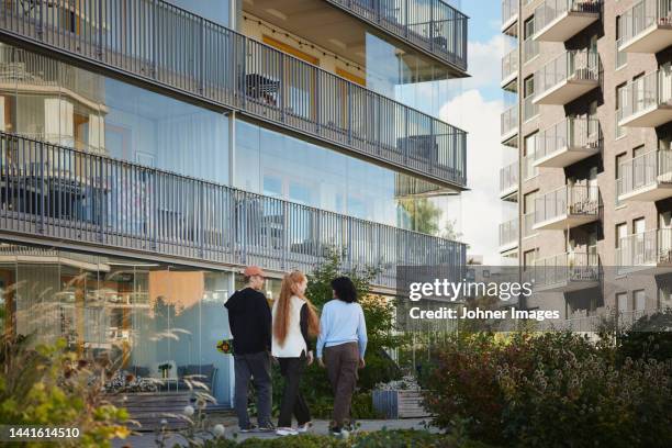 friends walking together - teenager outside apartment building stock pictures, royalty-free photos & images