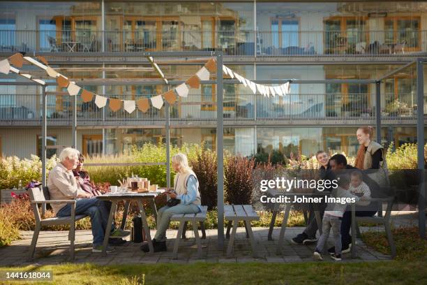 neighbors relaxing in communal outdoor area - coffee break party stockfoto's en -beelden