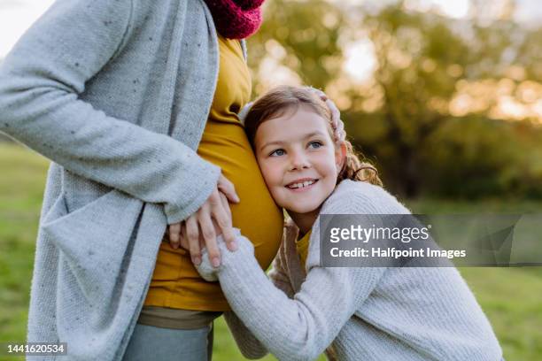 little daughter stroking pregnant belly of her mother. - little kids belly imagens e fotografias de stock